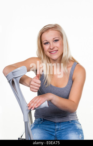 Une jeune femme avec des béquilles. Photo symbolique pour les accidents Banque D'Images