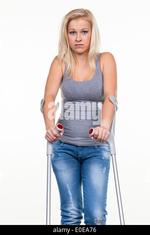 Une jeune femme avec des béquilles. Photo symbolique pour les accidents Banque D'Images