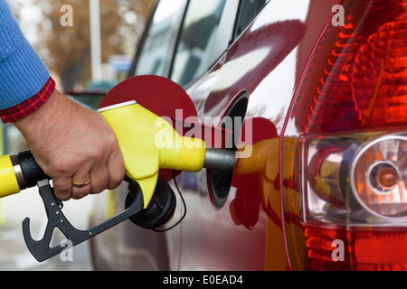 Une jeune femme d'essence du réservoir sur une station de charge. Les coûts pour la voiture deviennent de plus en plus cher en raison des coûts de pet Banque D'Images