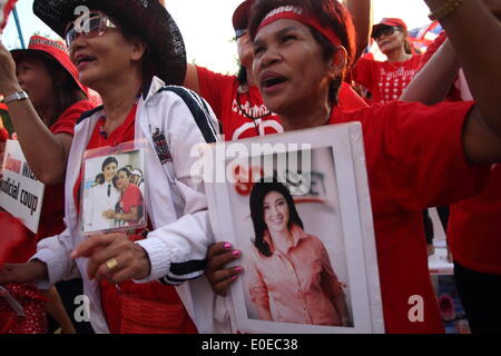 Bangkok, Thaïlande. 10 mai 2014. Chemises Rouges pro-gouvernement cheers au cours d'un vaste rassemblement à la périphérie de Bangkok. Les partisans du gouvernement sont massés à la périphérie de la capitale thaïlandaise dans une démonstration de force contre ceux qui cherchent à renverser des ex premier ministre Yingluck Shinawatra. Banque D'Images