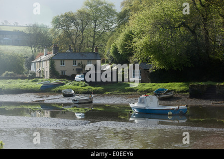 Un matin brumeux au village de Cornouailles Lerryn à marée basse sur la rivière à marées, avec le reflet dans l'eau des bateaux. Banque D'Images