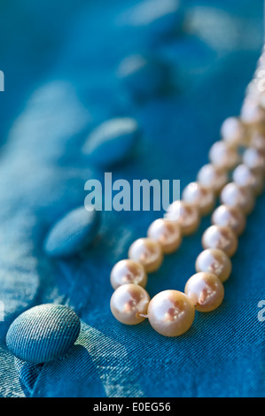 Collier de perles de couleur turquoise sur boutons de chemisier. Banque D'Images