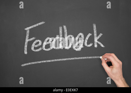 Une main écrit des commentaires sur un tableau. Banque D'Images