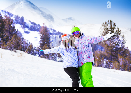 Femme souriante et des masques de ski homme embrasser les mains Banque D'Images