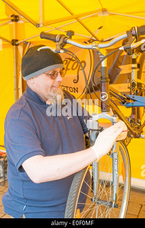 Mécanicien vélo de Bikestop travaillant sur location Darlington Arts Festival North East England UK Banque D'Images