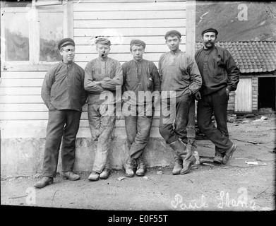 Une photographie historique des travailleurs de 1908, prise par A. Skrede, montrant la main-d'œuvre de l'époque. Cette image capture les individus impliqués dans diverses activités de travail manuel au début du XXe siècle en Norvège. Banque D'Images
