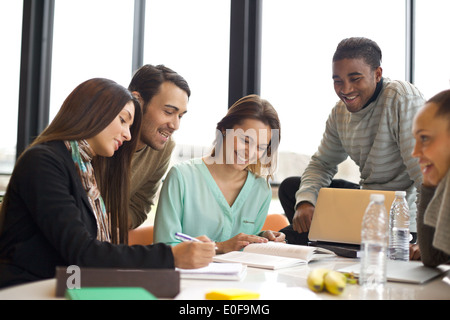 Groupe de jeunes étudiants multiraciale d'étudier ensemble à une table. Mixed Race les gens qui font de l'étude en groupe. Banque D'Images