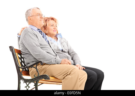 Senior couple hugging et regardant au loin assis sur un banc Banque D'Images