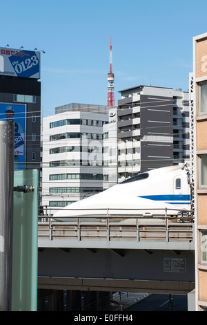 Bullet train passant entre les bâtiments au centre-ville de Tokyo, au Japon. Banque D'Images