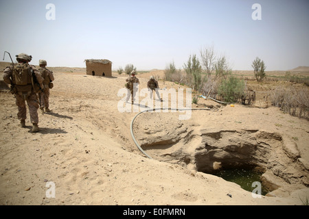 Les Marines américains avec la compagnie Bravo force d'assaut patrouille parle à la périphérie d'un village au cours d'une mission de contre-insurrection, le 1 mai 2014 dans Tagvreshk Village, province de Helmand, en Afghanistan. Banque D'Images