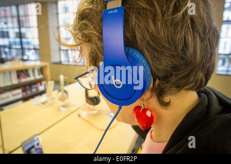 Un client essaye le casque Beats par l'électronique dans un Apple store à New York Banque D'Images