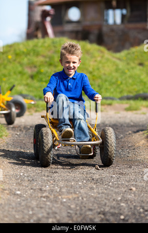 Garçon s'amusant avec panier buggy. Marques de commerce ont été supprimés. Banque D'Images