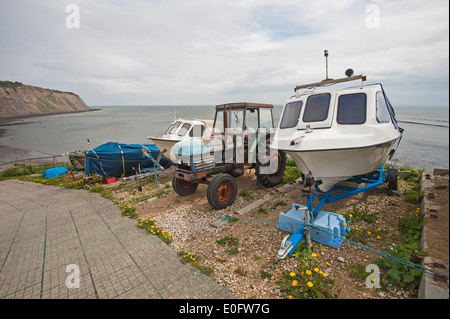 Petit bateau de plaisance et vieux tracteur sur la côte anglaise cale par la mer Banque D'Images