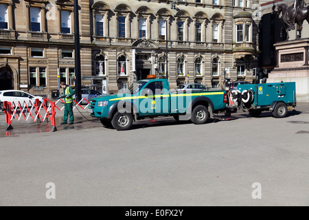 George Square, employé du Conseil de Glasgow, à l'aide d'un nettoyeur à pression pour nettoyer la surface grise, Écosse, Royaume-Uni Banque D'Images