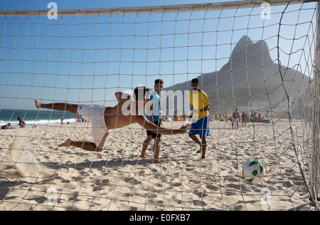 Brésil hommes jouant au football sur la plage de Leblon et Ipanema, Rio de Janeiro Banque D'Images