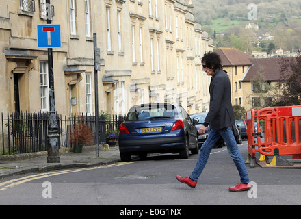 Plus à la mode mais l'homme de traverser la rue avec les travaux routiers sur une étroite rue sans issue dans la ville de Bath, 10 avril 2014 Banque D'Images