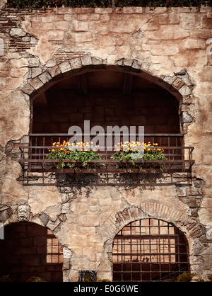 Mur d'une vieille maison rustique avec des fleurs sous un balcon, d''architecture de style vénitien Banque D'Images