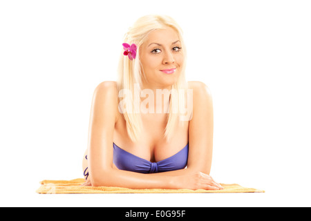 Femme blonde en bikini allongée sur une serviette. Banque D'Images