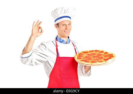 Male chef holding a pizza et faisant des gestes avec la main Banque D'Images