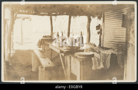 Une image historique d'une table de Noël dans les quartiers des hommes de Davenport Downs Station dans le sud-ouest du Queensland, datant de 1925. La photo présente des monuments historiques clés tels que les bâtiments de George James Smither, la Bibliothèque nationale Abercrombie d'Australie, et divers aspects du paysage environnant, y compris les arbres, l'herbe et un environnement vert. Banque D'Images