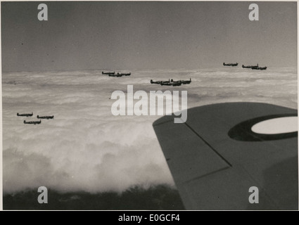 Un Supermarine Spitfire et un bombardier de la Royal Australian Air Force en vol, vers 1943, planant au-dessus des nuages pendant la IIe Guerre mondiale les avions font partie des efforts importants de l'aviation militaire de l'époque. Banque D'Images