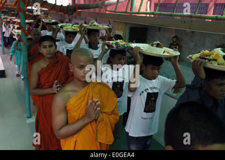 Dhaka, Bangladesh. 13 mai, 2014. Buddha Purnima, la plus grande fête religieuse de la communauté bouddhiste, est célébré dans tout le pays.En ce jour saint, Bouddha est né comme Kopilabostu Siddartha Gautam dans d'état indien du Bihar dans autour de 563 B.C., atteint l'illumination à l'âge de 35 ans (528 avant J.-C.) et enfin embrassé 'nirvana'' à l'âge de 80 ans (483 avant J.-C.).Les programmes comportent de hisser des drapeaux nationaux et religieux au sommet de tous les monastères et de récitation du versets sacrés de la Tripitak et la rupture de la porte par les moines.Selon la religion bouddhiste, le Bouddha était en Banque D'Images