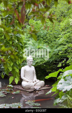 Statue de Bouddha dans un étang de nénuphars et de kois à Andre Jardin des Hellers, Giardino Botanico, Gardone Riviera, Lac de Garde, Lom Banque D'Images