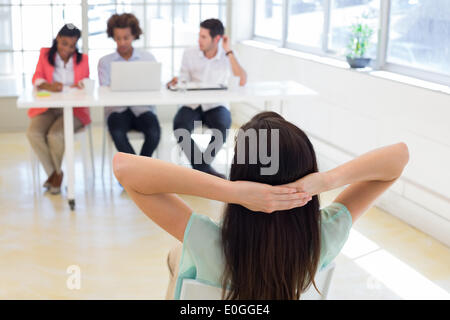Businesswoman se détend avec les mains derrière la tête Banque D'Images