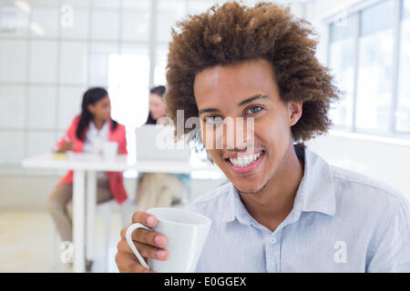 Young avec les collègues derrière lui Banque D'Images