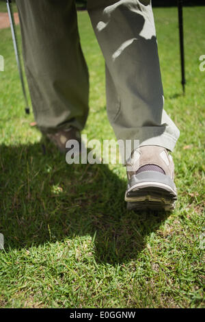 Pieds de femme en bottes de marche sur l'herbe Banque D'Images