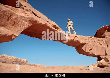 Voyageur debout sur rock arch à Wadi Rum, Jordanie, Moyen-Orient, Asie Banque D'Images
