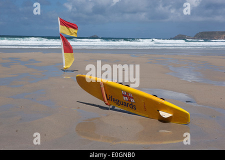 Conseil de surf sauveteurs et drapeaux d'avertissement sur une plage vide à Sennen Cove Cornwall Banque D'Images