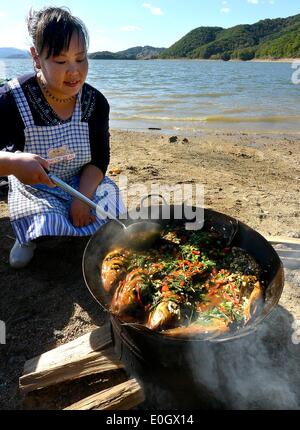 (140513) -- BEIJING, 13 mai 2014 (Xinhua) -- Photo prise le 26 septembre 2013 montre une femme cuisiner les poissons pour les touristes en plus dans le lac Songhua Jilin, au nord-est de la Province du Jilin en Chine. L'un des types les plus populaires dans le monde entier, la cuisine chinoise est célèbre pour son goût et la variété, avec une gamme incomparable d'ingrédients, les techniques, les plats et les styles. L'histoire de plats chinois remonte à des milliers d'années et a changé d'une période à l'autre et dans chaque région en fonction du climat, de la tradition et de préférences locales. Les Chinois sont fiers de manger une grande variété de fo Banque D'Images