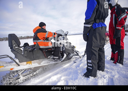 Antti, jeune guide finlandais de visitinari, explique comment conduire une motoneige dans le désert d'Inari, Finlande Banque D'Images