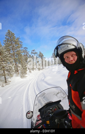 Antti, jeune guide finlandais de visitinari, conduit une motoneige dans le désert d'Inari, Finlande Banque D'Images