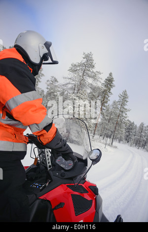 Antti, jeune guide finlandais de visitinari, conduit une motoneige dans le désert d'Inari, Finlande Banque D'Images