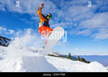 Snowboarder jumping de Hill en hiver Banque D'Images