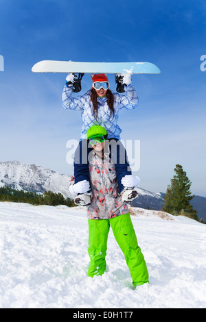 Snowboarder avec fille assise sur ses épaules Banque D'Images