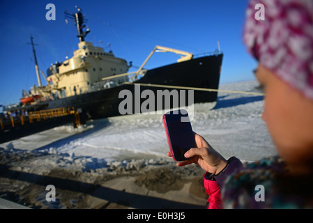 Jeune femme utilise le téléphone mobile pour prendre des photos de brise-glace sampo, une croisière en brise-glace finlandais authentique à touristiques Banque D'Images