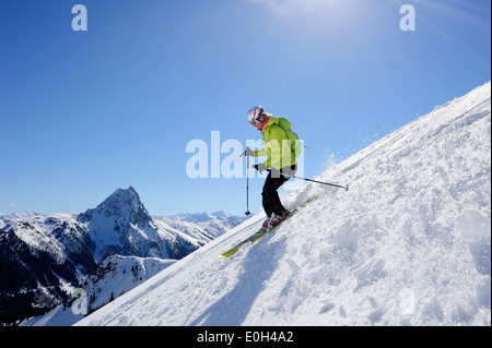 Femme skieur d'arrière-pays du ski de descente du mont Brechhorn, Grosser Rettenstein en arrière-plan, les Alpes de Kitzbühel, Brechhorn, Ty Banque D'Images