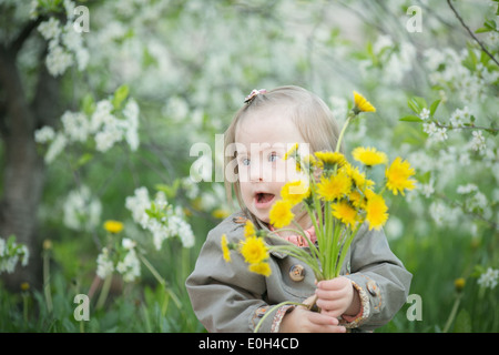 Petite fille avec le syndrome de Down est maintenant un bouquet de pissenlits Banque D'Images