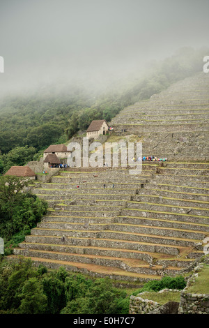 Les touristes avec manteaux de pluie en plastique sur les terrasses du Machu Picchu, Cusco, Cuzco, Pérou, Andes, Amérique du Sud Banque D'Images