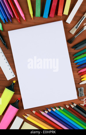 Ordinateur portable blanc vide avec des crayons, crayons et autre matériel scolaire Banque D'Images