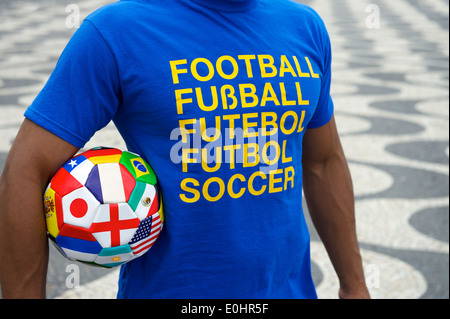 Brazilian soccer player portant maillot de football de l'équipe international holding soccer ball du pavillon de la plage de Copacabana à Rio boardwalk Banque D'Images