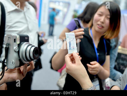 Kunshan, Chine, province de Jiangsu. 14 mai, 2014. En prenant de l'expérience visiteur photos Polaroid 2014 au cours de la Chine (Shanghai) Importation Expo à Kunshan, Jiangsu Province de Chine orientale, le 14 mai 2014. Les 4 jours de l'expo a débuté mercredi. Credit : Shen Peng/Xinhua/Alamy Live News Banque D'Images