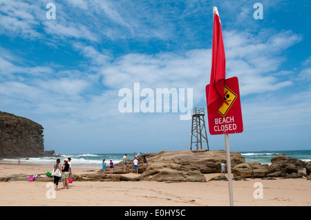 Redhead beach et les falaises près de Newcastle, Nouvelle-Galles du Sud, l'Australie avec de vieux lifeguard tower et plage signe clos. Banque D'Images