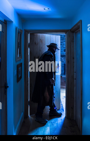 Un homme portant un chapeau et un long manteau de la saisie d'un prix. Banque D'Images