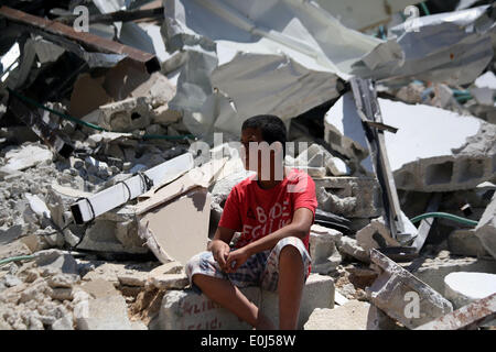 Jabal Al-Mukabe, Jérusalem, territoire palestinien. 14 mai, 2014. Un garçon palestinien ensembles sur l'rocailles de sa maison après démolir par des bulldozers de la municipalité israélienne sous prétexte de la construction sans permis, et ce, à Jabal al-Mukaber, district de Jérusalem est le 14 mai 2014. Israël a détruit plus de 500 propriétés palestiniennes en Cisjordanie et à Jérusalem-Est en 2013, le déplacement de plus de 850 personnes, selon les chiffres de l'ONU (crédit Image : © Saeed Qaq/APA Images/ZUMAPRESS.com) Banque D'Images