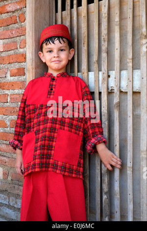 Petit écolier indonésien posant fièrement dans son uniforme de l'école dans un petit village rural à java Banque D'Images