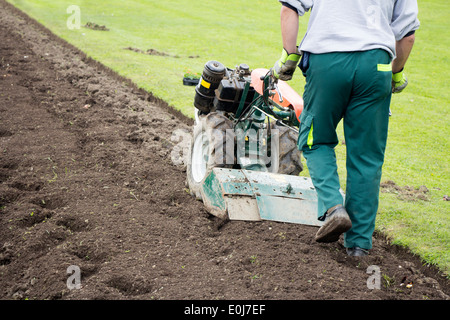 Homme travaillant dans le jardin avec timon Jardin Banque D'Images